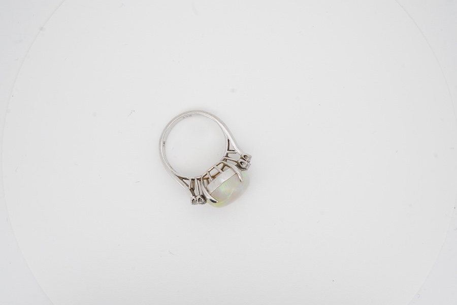 A 9k white metal and single stone cabochon white opal set dress ring, with ten stone diamond set shoulders, size P, gross weight 6.5 grams. Condition - poor